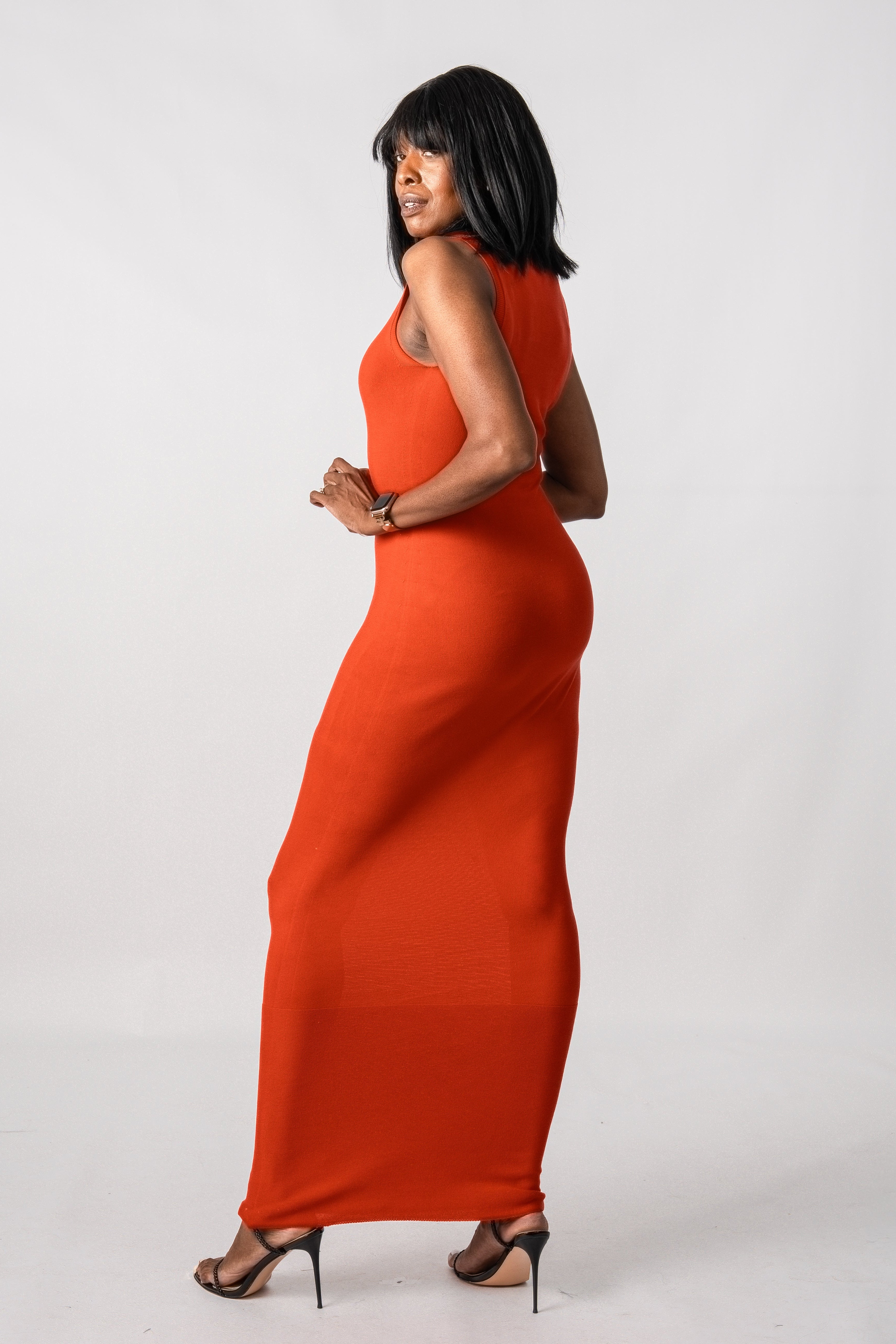 Woman wearing an orange dress against a white background
